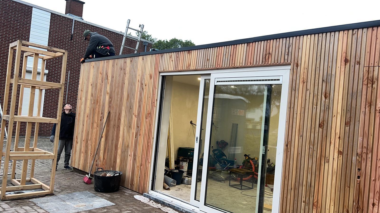 Houten uitbouw met grote glaspartij aan de tuinzijde